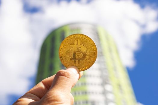 Bitcoin on the backdrop of a modern tall building