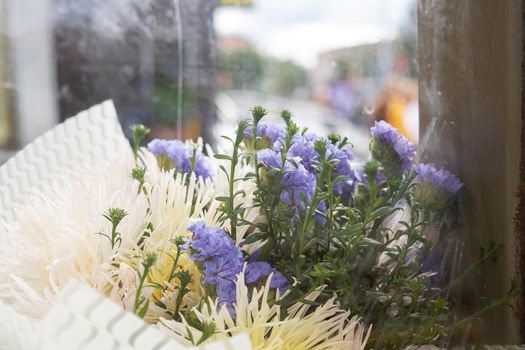 Bouquet of blue flowers behind the glass close up