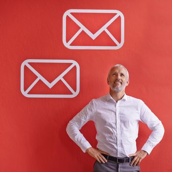 Digital marketing. a mature businessman standing against a red background with message symbols on it
