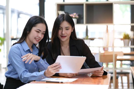 Two businesswoman meeting and working together on tablet in office...