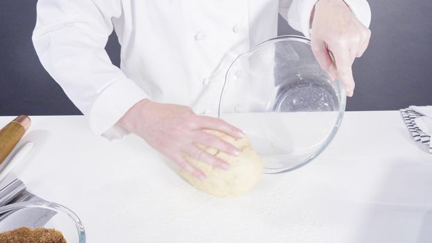 Knitting dough by hand to bake cinnamon rolls.