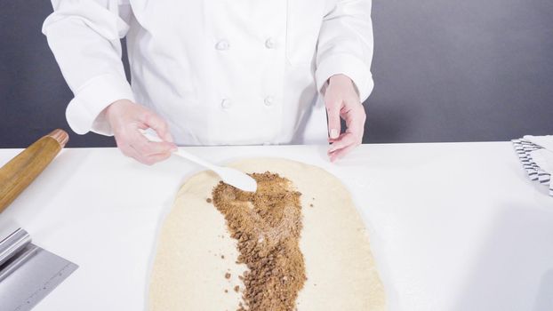 Rolling dough with a french rolling pin to bake cinnamon rolls.