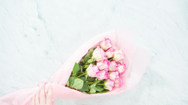 Flat lay. Step by step. Bouquet of pink roses on a concrete background.