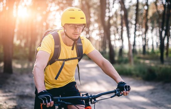 Man on bicycle cycling in sunny forest