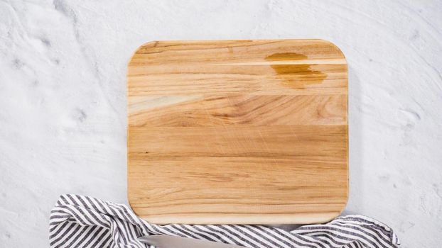 Flat lay. Step by step. Chopping organic green onions on a wood cutting board.