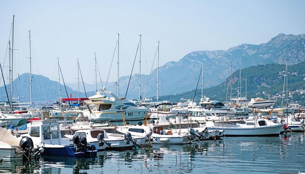 Yachts port in Montenegro in adriatic sea. Boats pier in sunny day with beautiful Mediterranean nature