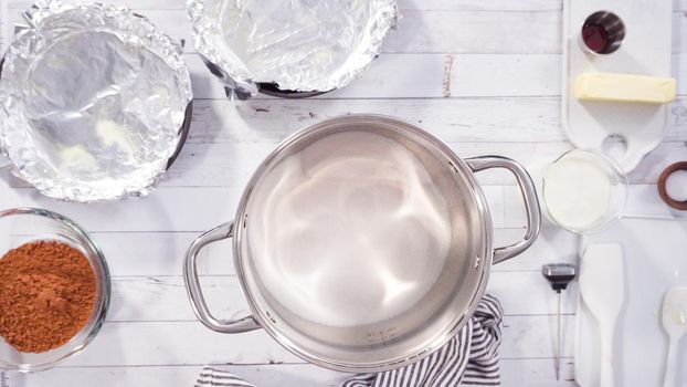 Flat lay. Step by step. Mixing ingredients in the cooking pot to make simple chocolate fudge.