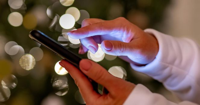 Person hand holding smartphone and typing message on mobile device. Human and modern technologies