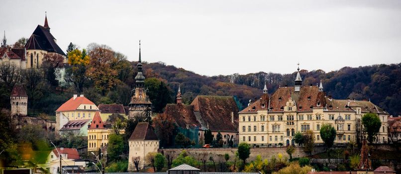 Ancient Sighisoara city in Romania, panoramic old clock tower, castle and medieval architecture view. Historic european town with heritage and Dracula house