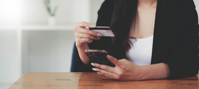 Woman hands holding smartphone shopping online with credit card. Online Payment. Online shopping concept..