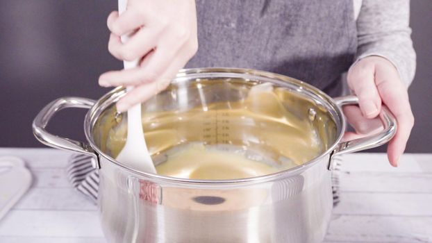 Step by step. Melting white chocolate chips in the cooking pot to make candy cane white chocolate fudge.