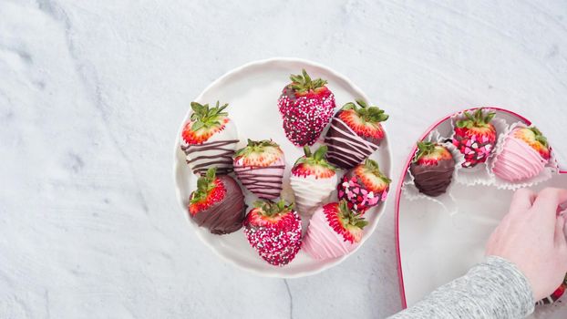 Flat lay. Step by step. Placing chocolate dipped strawberries on a white cake stand.