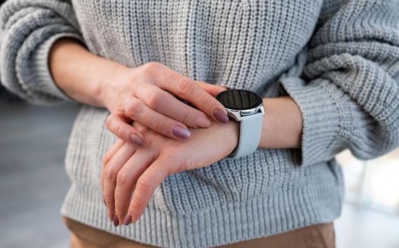 Person with smart watch on hand looking at time on digital screen with copy space. Girl with innovative electronic clock