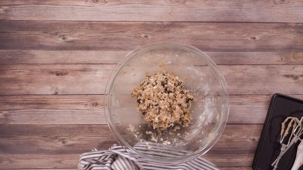 Flat lay. Step by step. Mixing ingredients to bake oatmeal raising cookies in a glass mixing bowl.