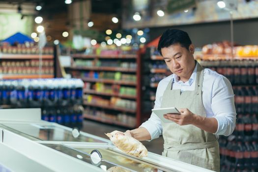 portrait of happy asian male shopkeeper with tablet