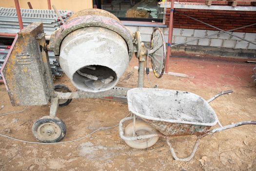 dirty concrete mixer near the construction of a house on the ground building materials, renovation. High quality photo