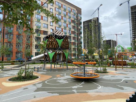 Colorful children's playgrounds in the courtyard of a residential building. Safe modern playground. Arrangement of the courtyard of a new building.