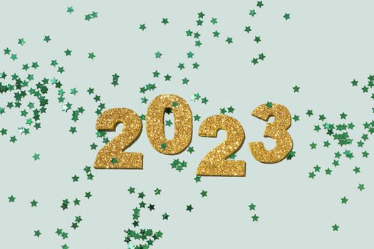 Shiny gold numbers 2023 on a pastel green background. Festive New Year background.