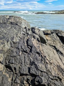 A surf on a rocky beach with black sand in Iceland