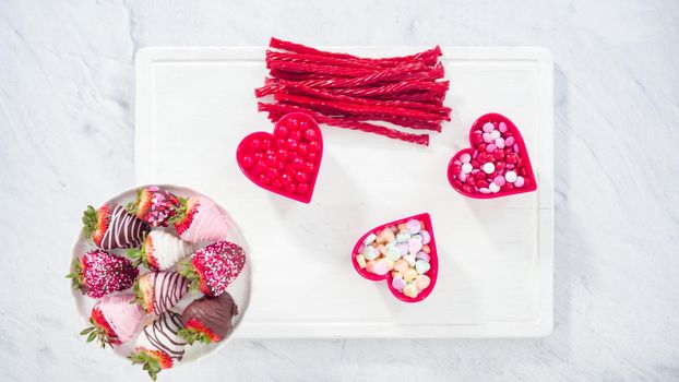 Flat lay. Step by step. Cheese board with candies and cookies for Valentines Day.