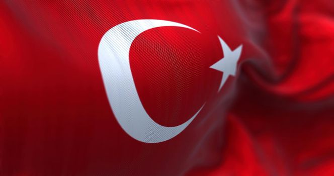 Close-up view of the Turkey national flag waving in the wind. Turkey is a transcontinental country located mainly in Western Asia. Fabric textured background. Selective focus