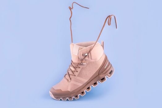 woman cream hiking boot,isolate on a blue background