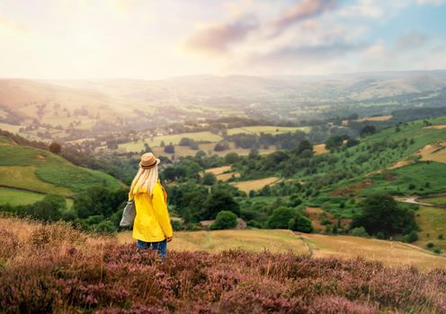 a young woman in a bright yellow raincoat walking in the fields of the Peak District