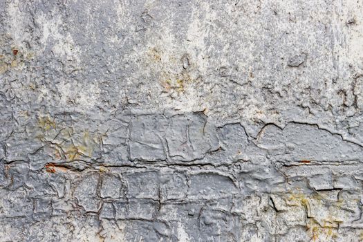 Old rough cement wall without plaster, damaged due to moisture and microorganisms.