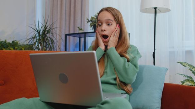 Oh my God Wow. Amazed student girl child kid use laptop computer receive good news message. Young woman shocked by sudden victory, celebrate win, purchases online shopping at home. Modern technologies