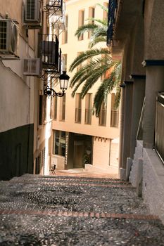 Benidorm, Alicante, Spain- September 9, 2022: Narrow cobbled street with vintage street light in Benidorm