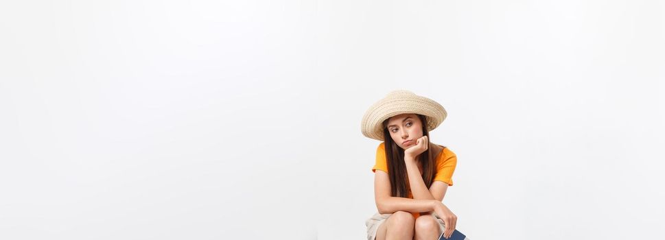 Lifestyle and travel Concept: Young beautiful caucasian woman is sitting on suitecase and waiting for her flight.Isolated over white background.