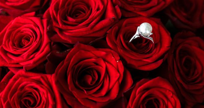 Gemstone jewellery, wedding present and engagement proposal concept - Beautiful white gold pearl ring and bouquet of red roses, luxury jewelry love gift on Valentines Day and romantic holidays