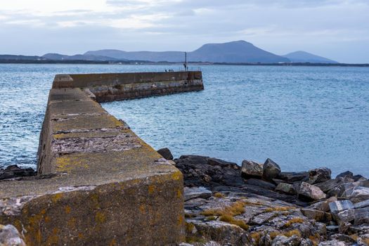 A beautiful image of a breakwater structure in the sea in Alesund, Norway; beach background