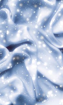 Winter fashion, shiny fabric and glamour style concept - Magic holiday blue soft silk flatlay background texture with glowing snow, luxury beauty abstract backdrop