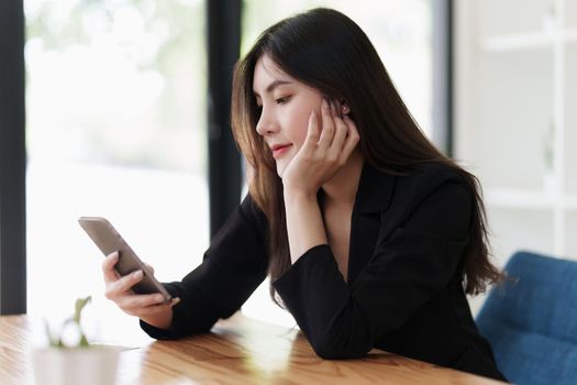 Young asian business woman smiling and chatting on mobile phone.