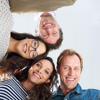 Confident in our collaborative planning. Low angle shot of four people smiling down at the camera positively