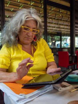 mature woman customer ordering food at restaurant using digital tablet