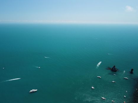 Aerial boat race. Luxury cruise trip. View from above of white boat on deep blue water. Aerial view of rich yacht sailing sea. Motor boat racing wave. Summer journey on luxury ship