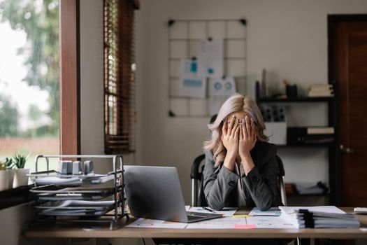 Businesswoman get stressed and feel headache while having a problem at work in office.