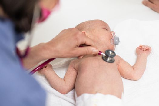 Baby lying on his back as his doctor examines him during a standard medical checkup.