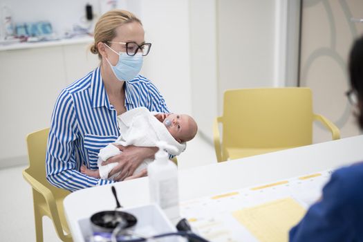 Mother holding her baby boy at medical appointment at pediatrician office