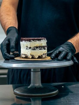 professional baker decorating a chocolate and cream cake with salty caramel