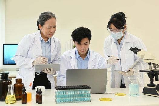 Senior woman scientist and young researcher collecting data and summarising information for scientific report.