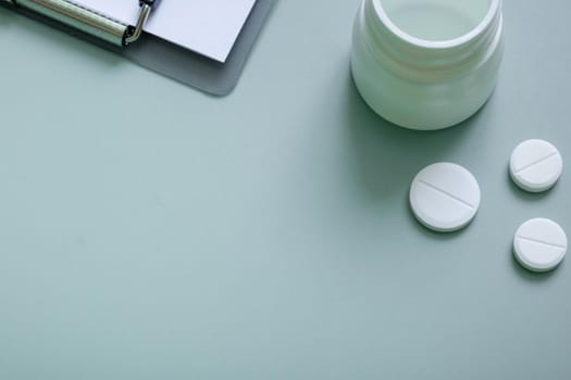 Pills and a tablet on colored background. Medical backdrop with copy space.