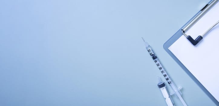 Banner with syringes and a tablet on colored background. Medical backdrop with copy space.