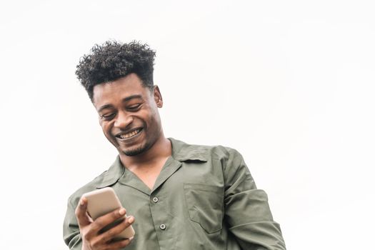 portrait of an attractive young african black man looking the phone in white background, lifestyle and technology concept, copy space for text