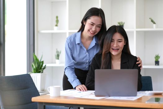 Two Young Asian businesswoman discuss with new startup project Idea presentation, analyze planning and financial statistics and investment market at office..