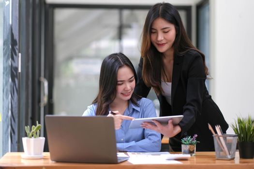 Two Young Asian businesswoman discuss with new startup project Idea presentation, analyze planning and financial statistics and investment market at office..