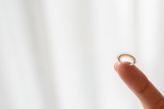 Close up of contact lens on finger.