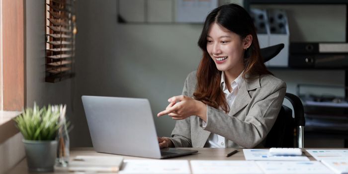 Asian Business Woman or Accountant do math and analyze with calculator and paperwork on desk, account, audit and saving concept.